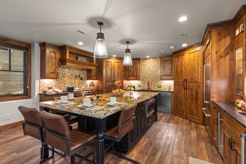 Whip up a meal in this fully-equipped kitchen, featuring a large island with bar seating, granite countertops, and modern amenities.