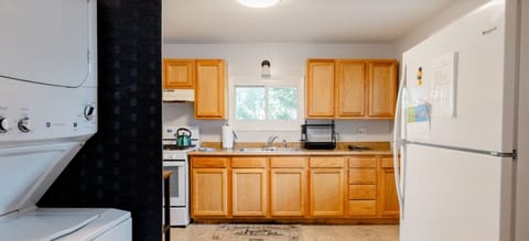 Entering the kitchen is the refrigerator and washer dryer left.