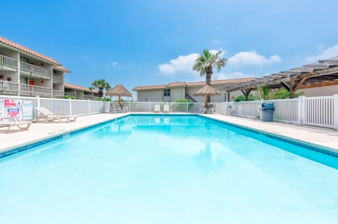 Dive into crystal-clear waters surrounded by tropical palms and tiki-style shade umbrellas, creating your perfect poolside paradise.