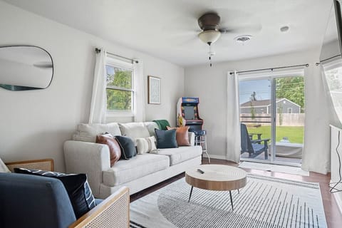 Exquisite living room with comfortable couches, pillows, and a glass door that invites an abundance of natural light to fill the space.
