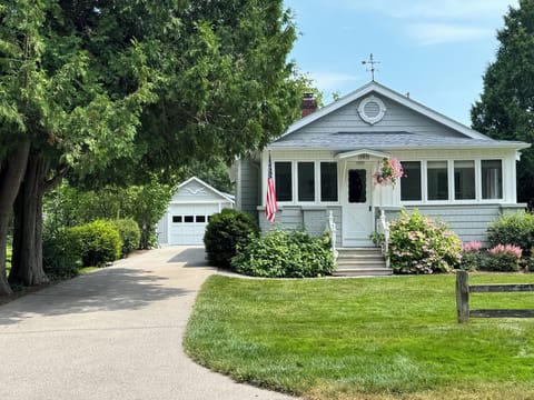 Cottage exterior.  Garage with Weber grill, beach chairs