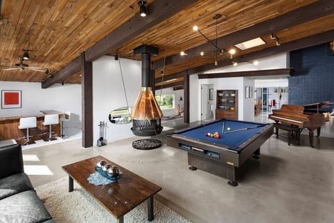 Great Room with pool table and piano. Bar area beyond.