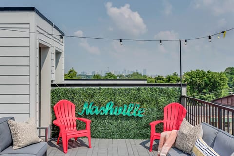 Step outside of the rooftop that hosts two sofas, colorful adirondack chairs, a loveseat, string lights, a light up Nashville sign, and corn hole/bags game