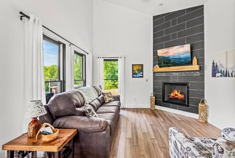 Cozy living room with gas fireplace, comfortable furniture, Smart TV, and lots of natural light.