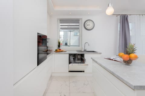A modern kitchen layout with white cabinets and a convenient island. Perfectly organized for cooking and hosting.