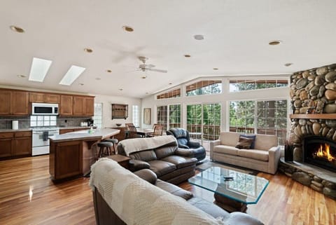 The open and social living/kitchen/dining room is flooded with natural light thanks to the wall of soaring floor-to-ceiling windows.