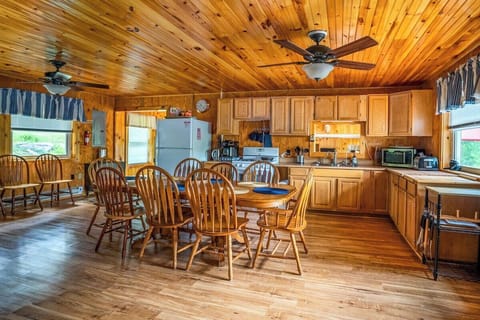 View from right side of kitchen facing the large refrigerator, gas stove and appliances on counters. Also an overhead fan for keeping it cool while in Kitchen.