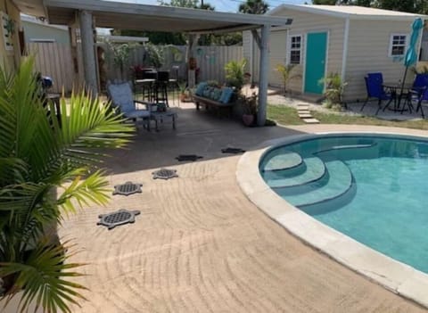 In ground pool with covered patio & surrounding pool concrete patio for sunning 