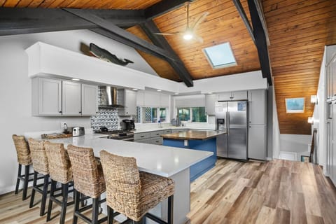 Gather at the breakfast bar overlooking the Chef's kitchen with large gas range, stainless-steal appliances and plenty of skylight counters.