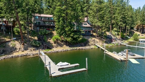 Waterfront retreat featuring private docks and direct lake access surrounded by towering evergreens.