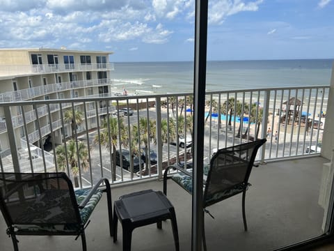 Top floor oceanfront balcony with beach, pool and palms.
