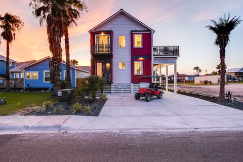 Vibrant beachside property with palm trees and elevated design in a coastal neighborhood during golden hour.