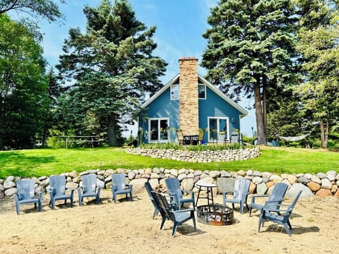 The house features a sand beach, fire pit, and cement patio over-looking Huron