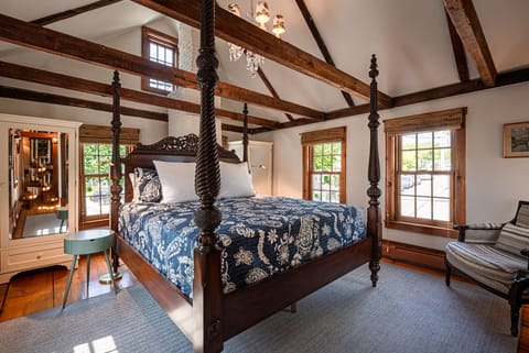 Enjoy serene slumber in the primary suite’s king-size four-poster bed
