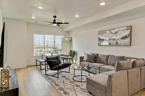 Spacious living room with plush seating, dining area, and large windows for a bright and welcoming atmosphere 🌞🛋️🍴