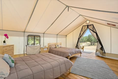 Two comfortable queen beds inside with a propane heater in your tent