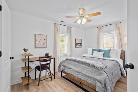 Peaceful master retreat with queen bed, ensuite bath & workspace.  Unwind in this serene bedroom featuring soft linens, a ceiling fan, closet storage, and a dedicated desk for remote work or journaling.