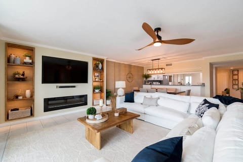 Modern living room with a large white sectional sofa and built-in shelving around the television.