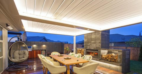 This outdoor living space is designed to bring people closer — with the spa, dining area, and fireplace creating beautiful holiday memories together.