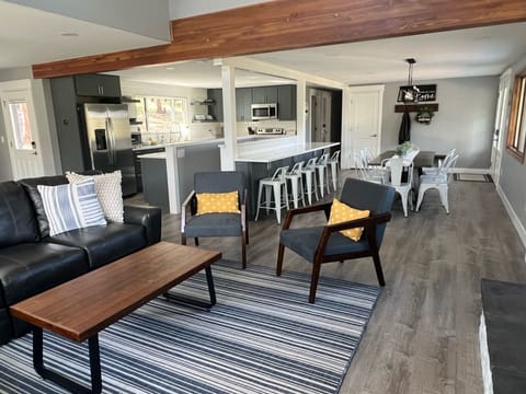Living room opens to a large kitchen and dining area. Dining table seats 8