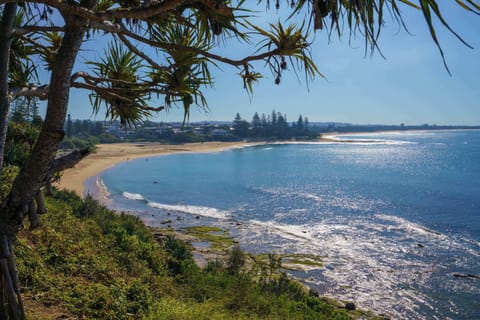 Bright coastal apartment exterior nestled near Moffat Beach and local cafés