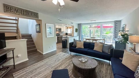 Open living area with modern seating and natural light from sliding glass doors.