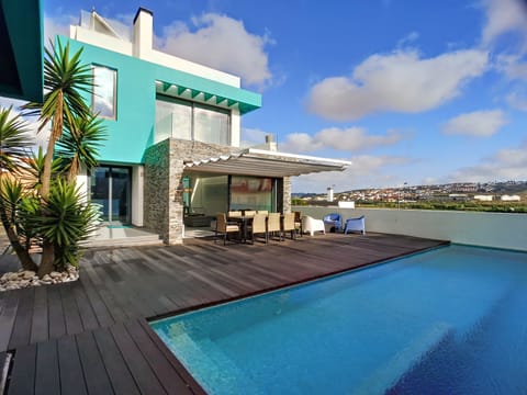 Backside of the house: pool, deck, dinner table, lounge area