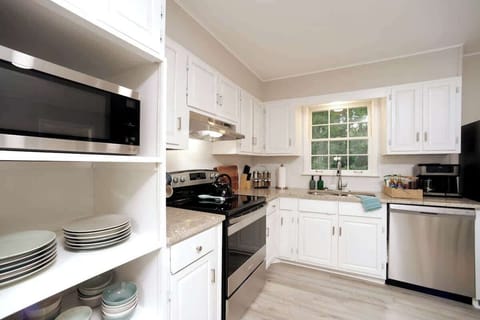 Fully stocked with dishes and a microwave.