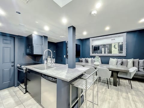 Full-size kitchen with brand new state-of-art Samsung stove, convection oven, air fryer, island bar with in-kitchen dining, entertaining 70-inch smart TV in the dining room, 50-inch in kitchen, stone dining table for up to 12 persons & bar seating.