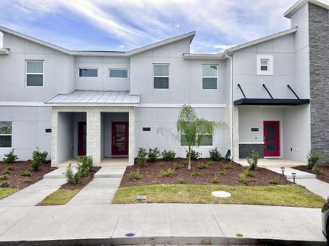 Welcome to your modern townhome retreat! Sleek gray exterior, bold red doors.