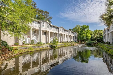 Property exterior overlooking pond with lush landscaping