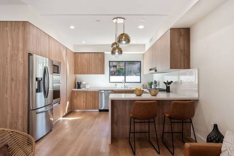 Modern kitchen with waterfall counter with designer three tier chandelier