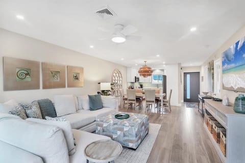 Relax in your bright, coastal-themed living space with plush sectional seating and ocean-inspired decor throughout the open floor plan.
