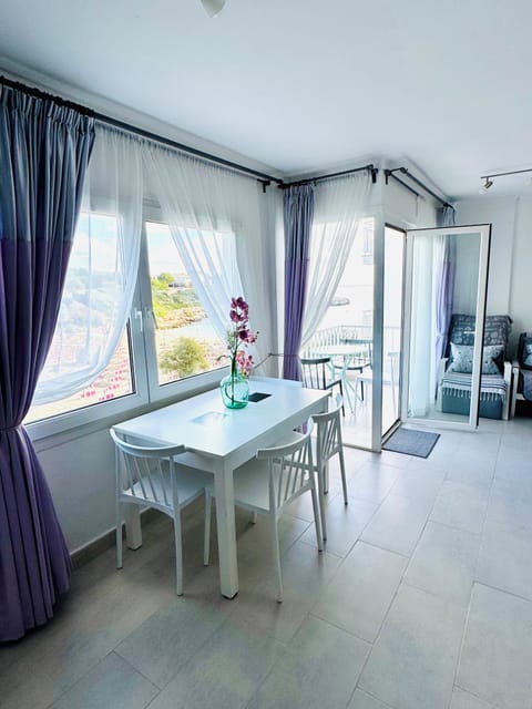 Bright, sun-filled living space with large windows framing the Mediterranean Sea