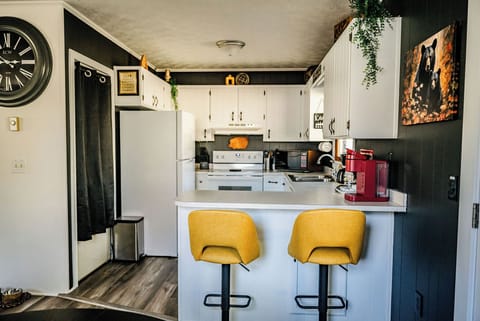 Cozy kitchen with modern appliances and bright yellow stools at the counter.