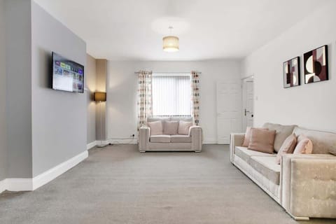 Bright, spacious living area with a Smart TV and ample seating, offering a comfortable space to relax, enjoy your favourite entertainment, or spend quality time together during your stay.