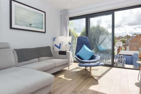 Lower ground floor sitting area with bi‑fold doors opening to the garden and outdoor dining space.
