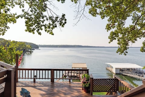 Lake views and waterfront property that includes a private boat dock and lawn.