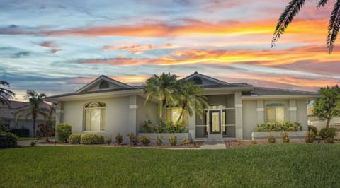 Incredible home is surrounded by large palms and tropical landscaping.