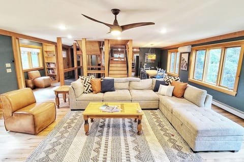 Open concept floor plan, looking from the living room, dining room on the right, reading nook on the left, and kitchen and bar on the far side of the stairs.  Nature just outside, coming in through the windows!