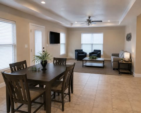 Bright open living & dining space with cozy seating and TV