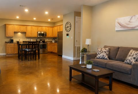 Spacious open living area with full kitchen, dining table, and cozy sofa