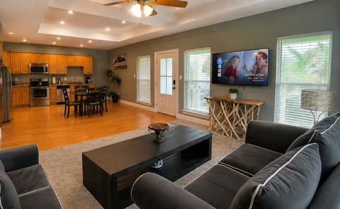 Bright open-concept living room with full kitchen and cozy lounge seating