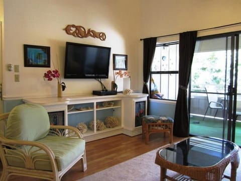 Sink into the sofa in your bright living area, where tropical touches and a flat-screen TV create a relaxing retreat. Step through the doors to your private balcony and enjoy the green views beyond.