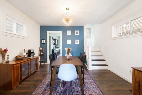 Enjoy meals at the warm wood dining table, then head upstairs or brew a fresh cup at the coffee station. Bold accent wall, framed art, and mid-century touches add style throughout! 