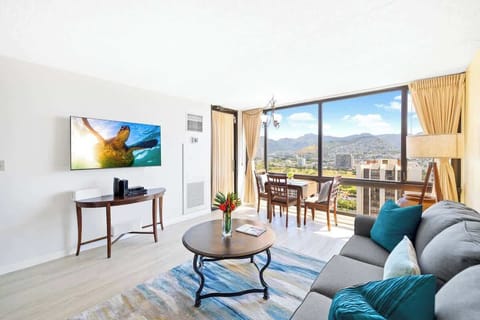 Enjoy the spacious, light-filled living area with a 55" Smart TV and panoramic views of the city and mountains through your expansive windows.