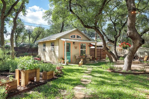 Private gate entry to a lush organic garden with herbs, veggies, and blooms.