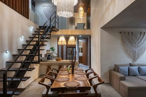 Stylish living room with local décor, macramé wall art, and hanging lamps.