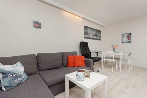 Bright living room featuring a gray sofa, white coffee table, and modern decor, creating a cozy space.

