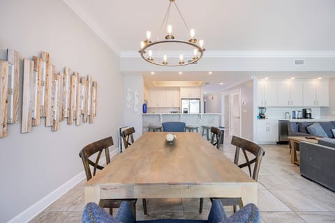 Gather at the large wood dining table under the chandelier for family meals or a fun game night